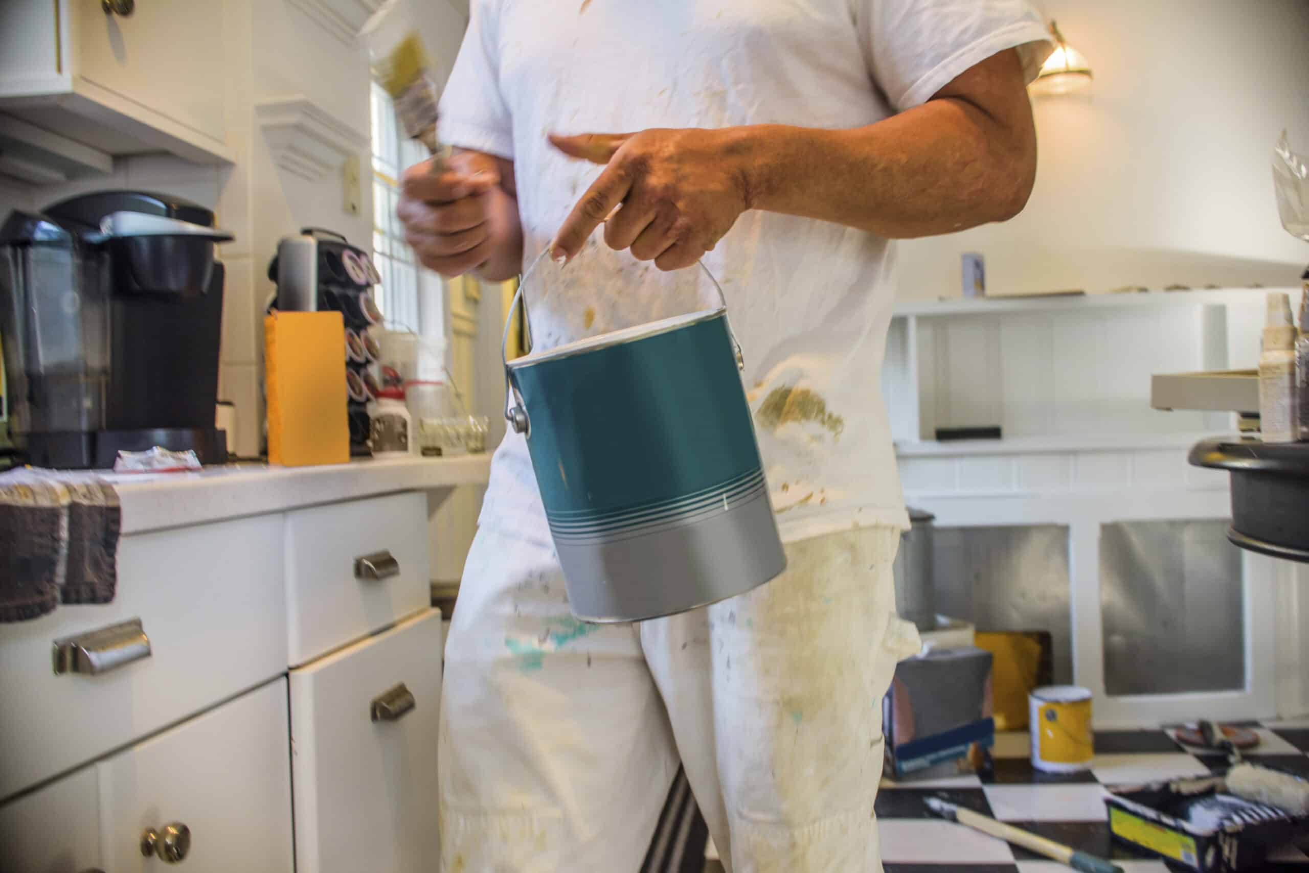 Cropped view of man in kitchen holding paint can